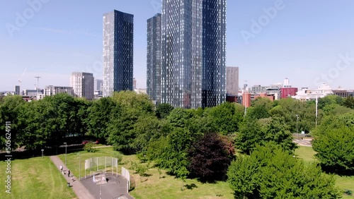 revealing shot of deansgate square starting in hulme park skatepark manchester city center photo