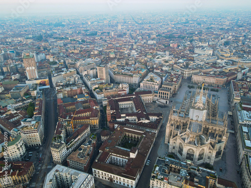 Aerial view of Duomo di Milano Cathedral in Duomo Square. Gothic cathedral in the center of Milan. Drone view of the gallery and Milano rooftops  in north Italy  Lombardia. Birds eye of Duomo facade.
