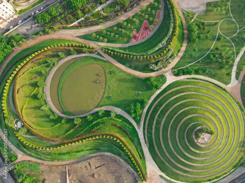 Aerial view of Parco del Portello in Milan, near CityLife, Lombardia. View from the height of park with a green lawn and paths. Abstract design similar to a dragon. Drone photography in Milano. photo