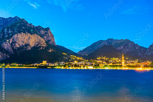 The city of Lecco, with its lakefront and its buildings, photographed in the evening. 