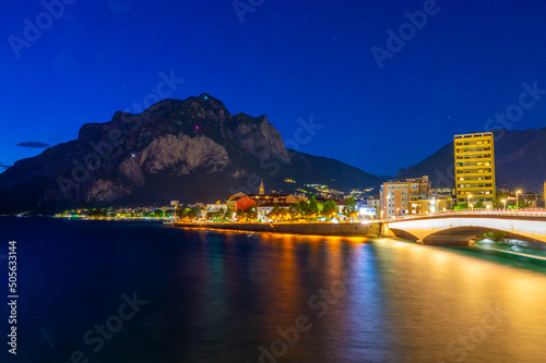 The city of Lecco, with its lakefront and its buildings, photographed in the evening. 