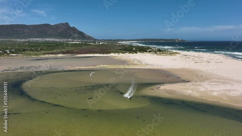 Drone tracking kitesurfer in shallow beach pond flip upside down in high air