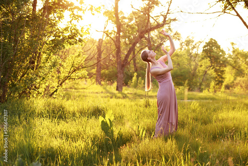 A woman in a dancer's dress dances in nature in the summer. postcard. banner. copyspace