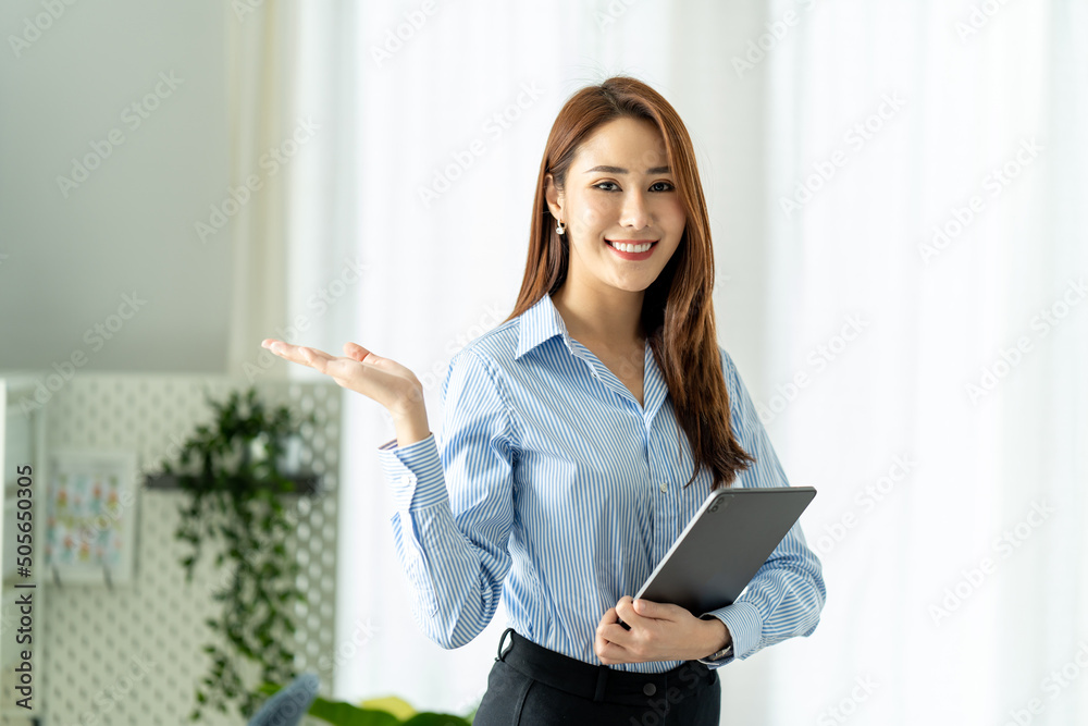 Creative Asian young woman working on tablet in her studio. Creative Asian young woman working on tablet in her studio.