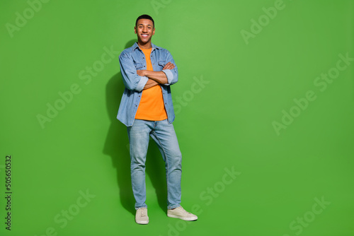 Full body photo of young intelligent entrepreneur man with folded hands isolated on green color background