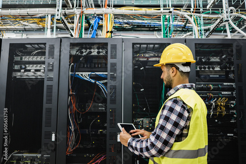 Photography Young technician man working inside big data center room - Focus on face