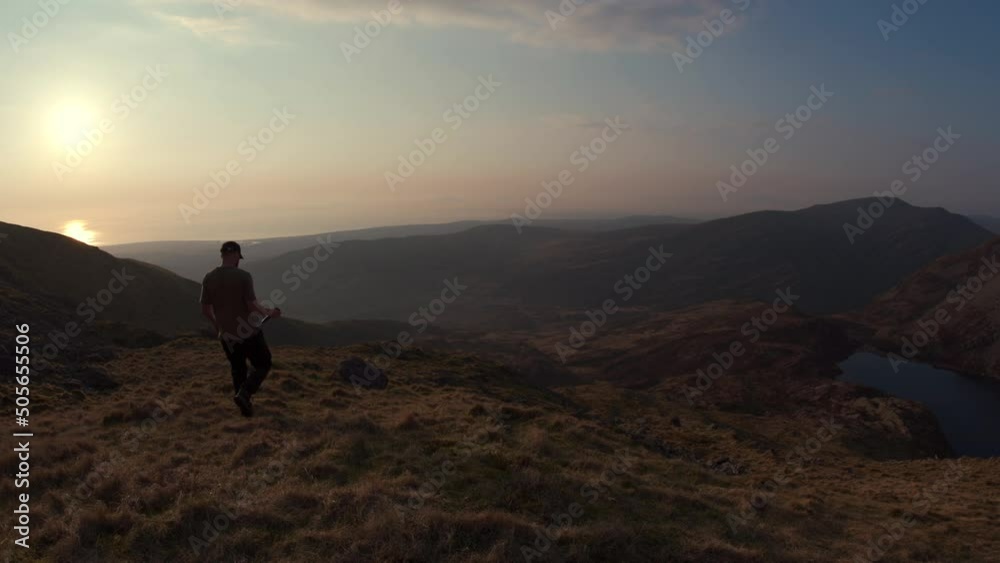 A photographer setting up a camera high in the mountains of Wales A photographer setting up a camera high in the mountains of Wales