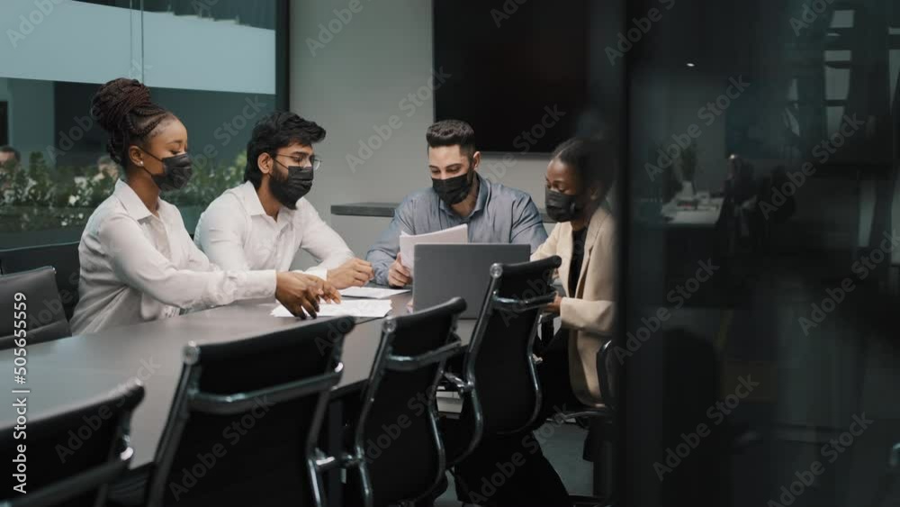 Multiethnic business team diverse partners workers colleagues in medical protective masks in office working discuss startup project analyzing financial documents strategy ideas coronavirus pandemic Multiethnic business team diverse partners workers colleagues in medical protective masks in office working discuss startup project analyzing financial documents strategy ideas coronavirus pandemic
