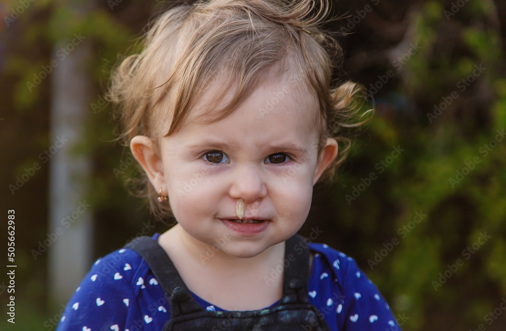 Wall Mural Baby plays snot in the street with a cold nose. Selective focus.