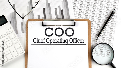 Paper with COO - Chief Operating Officer on a chart with calculator,pen and magnifier photo