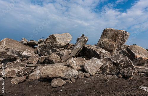 big pile of construction rubble of a demolished building under a blue sky