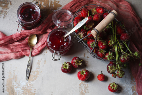 Summer breakfast concept with srawberry jam and fresh harvested berries in a basket, flat lay, copy space. photo