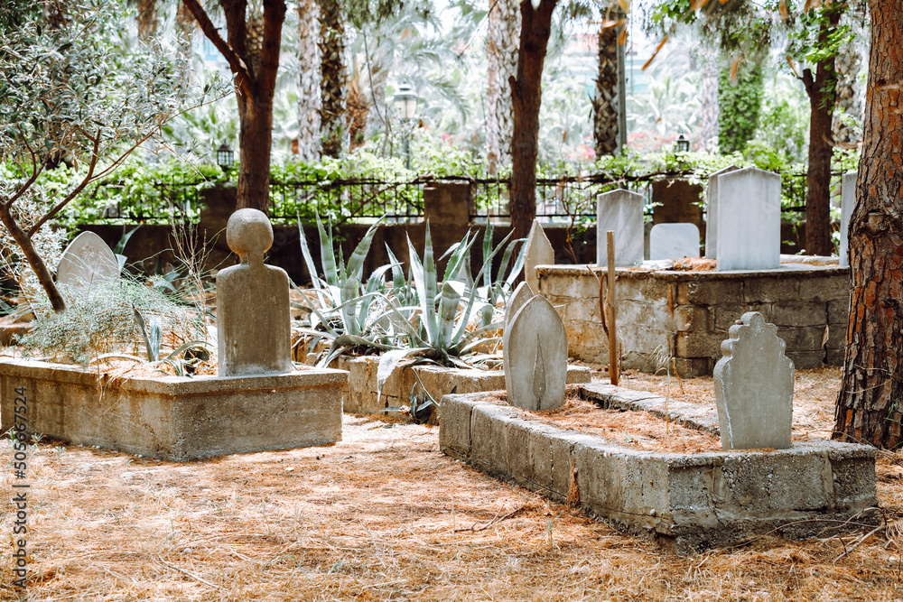 Blank tombstones and graves in an ancient church graveyard on a sunny day