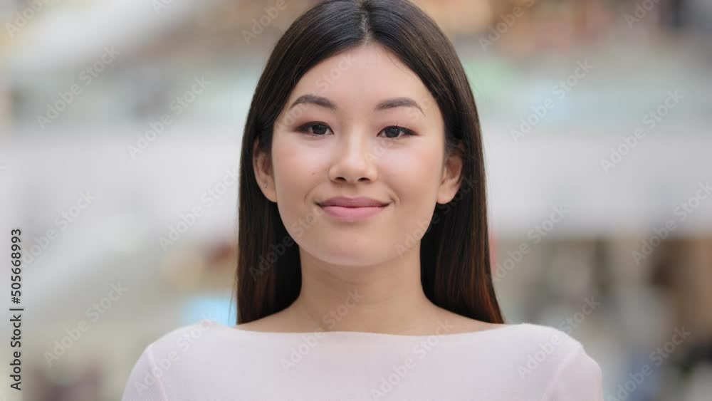Close up female indoors headshot Asian happy smiling millennial girl. 20s brunette woman model lady with natural make-up face cosmetology service. Businesswoman worker manager client looking at camera