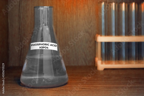 Selective focus of Phosphoric acid solution in gray flask. Blur white laboratory colbs. High quality photo