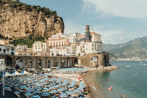 Fototapeta Naklejka Na Ścianę i Meble -  Panoramic view of Atrani, the city on the Amalfi coast, with beach, parasols, and people, enjoying a rest on the beach