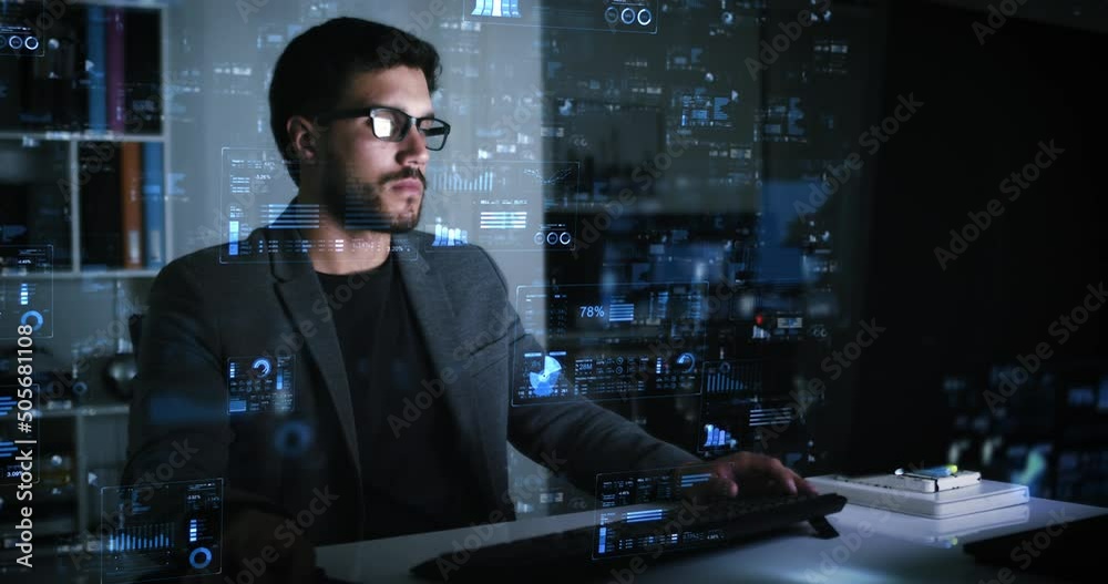 
 Broker Businessman Checking Stock Exchange Information at Night in Office. Young Caucasian Male Using Computer With Holographic Animated Financial Charts and Data. VR, AR. Graphic User Interface.