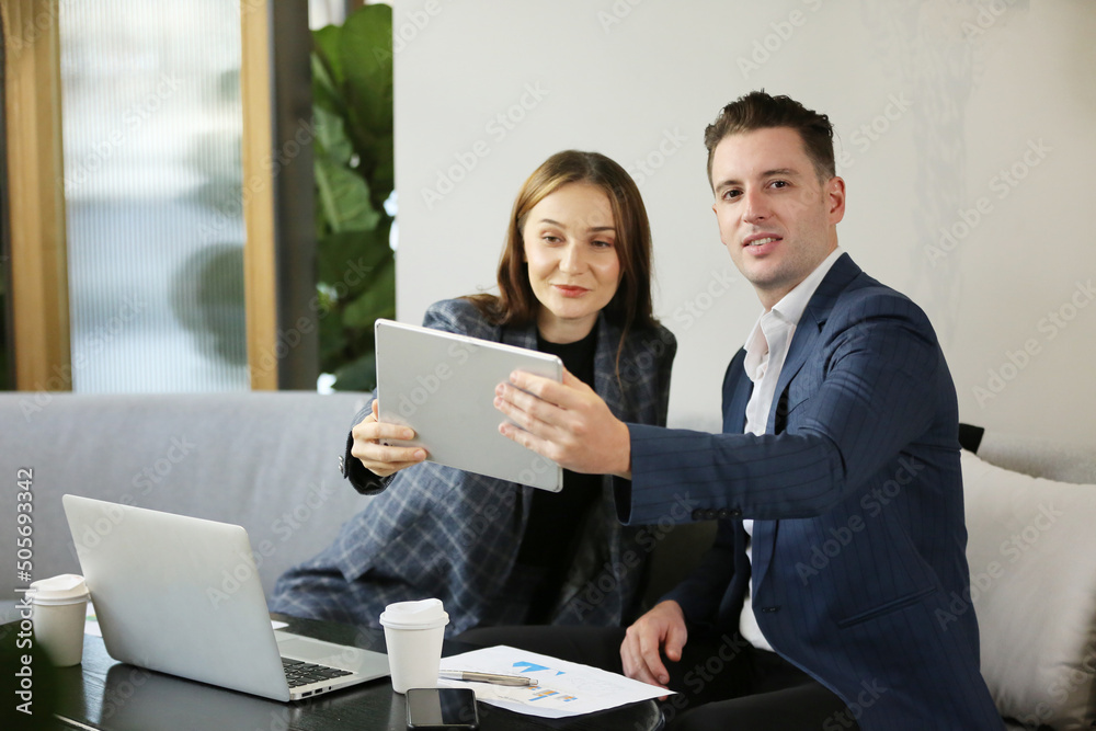 people working at startups, Two business people smiling and brainstorming while using laptop. people working at startups, Two business people smiling and brainstorming while using laptop.