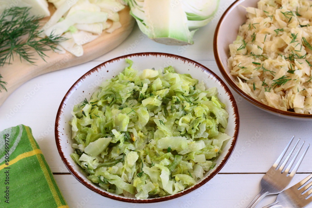 Fototapeta premium Stewed young cabbage sprinkled with chopped dill. Spring vegetable dishes. Vegetarian cooking 