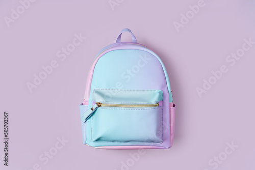 School backpack in pastel color on pink background. Concept back to school. photo