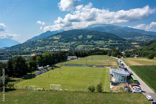 Drone view of a mountain landscape in Austria with a football field. Football pithc among fields and alpine mountains photo