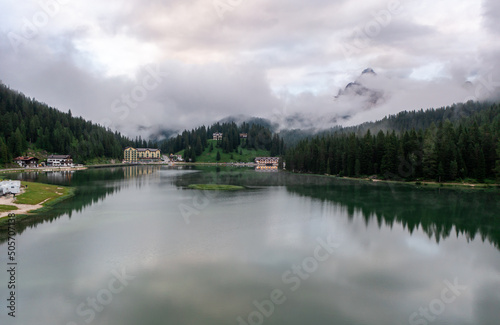 Panorama drone view of Lago di Misurina, reflection of the mountain in the lake, flying through the fog in the Dolomites in Italy © Rauf
