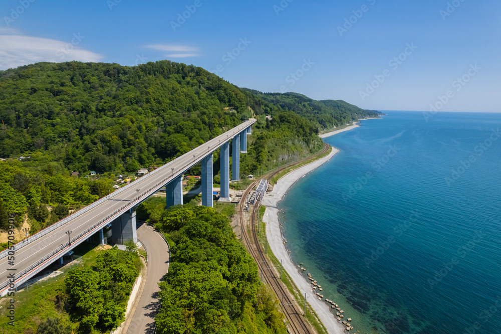 The Zubova Schel Viaduct is a road bridge, Dzhubga - Adler federal road. Aerial view of car driving along the winding mountain road in Sochi, Russia.