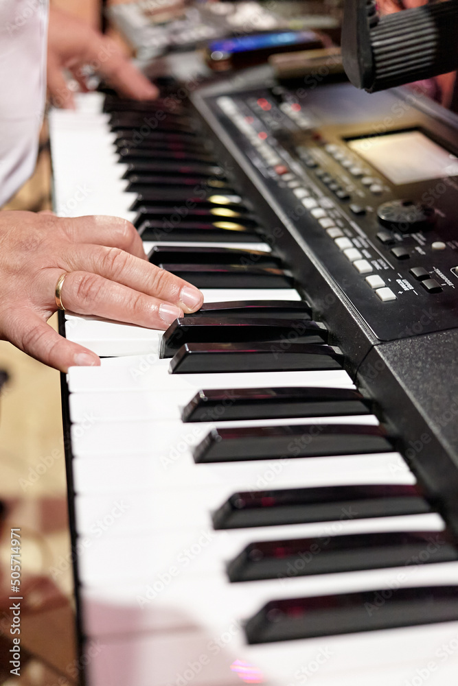 Obraz premium Hands of a pianist playing on an electric synthesizer