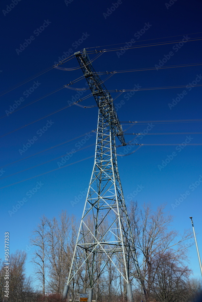 Hochspannungsmast vor blauem Himmel