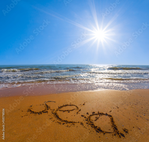 sandy beach with sea sign under sparkle sun  summer sea landscape
