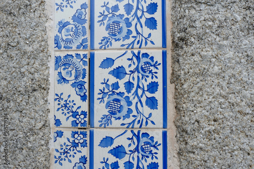 Vintage floral tiles of white and blue colour on the stone wall facade in Porto, Portugal