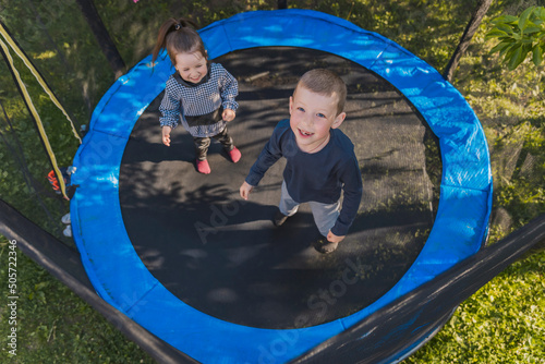 children jumping on a trampoline top view