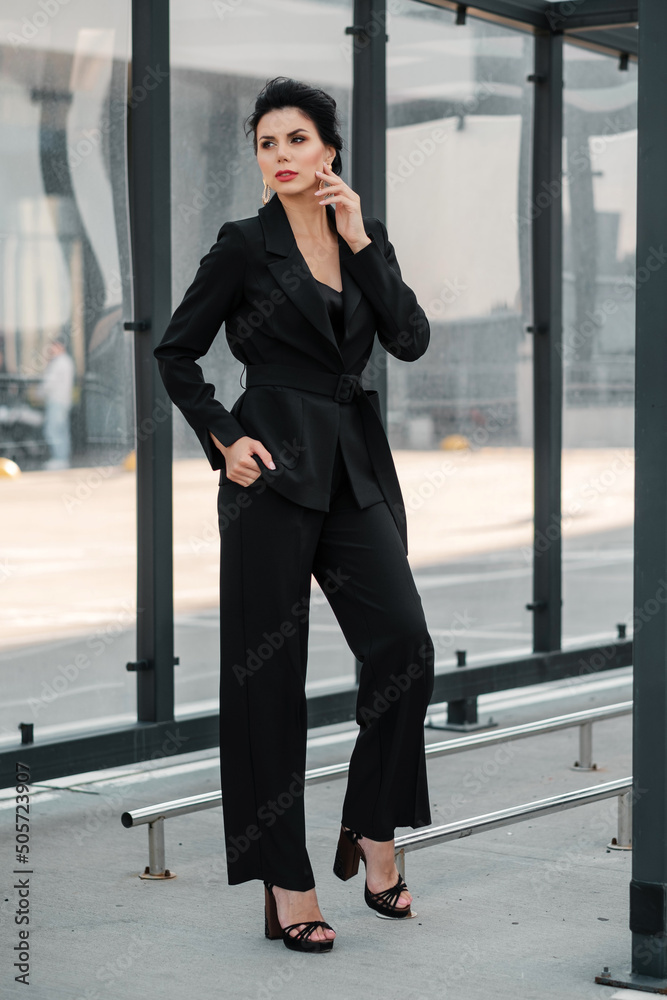 Female posing in pantsuit outdoors and looking at camera Female posing in pantsuit outdoors and looking at camera