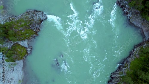 Close-up of a drone camera flying over the rapids of a mountain river. Flight of the drone camera over the streams of picturesque Siberian mountain river. Scenic nature video.
