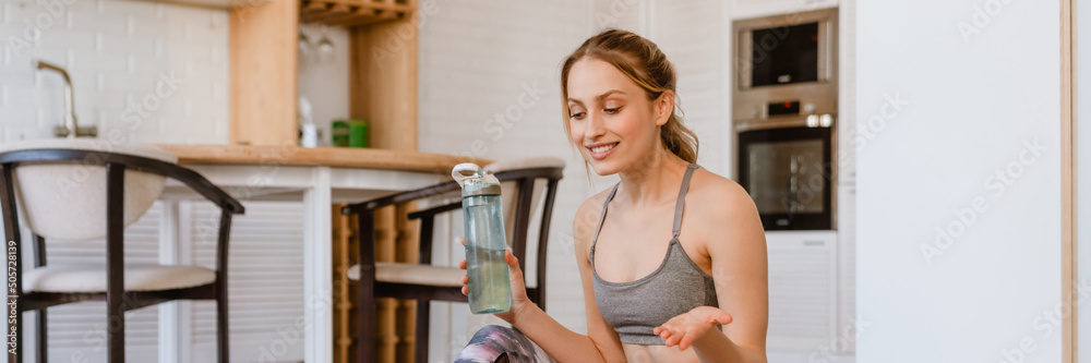 Young white woman gesturing and using laptop during yoga practice Young white woman gesturing and using laptop during yoga practice