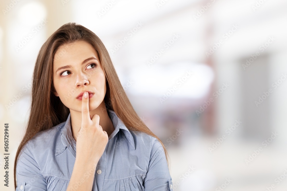 Thoughtful woman keeps hand on chin looks pensively Thoughtful woman keeps hand on chin looks pensively