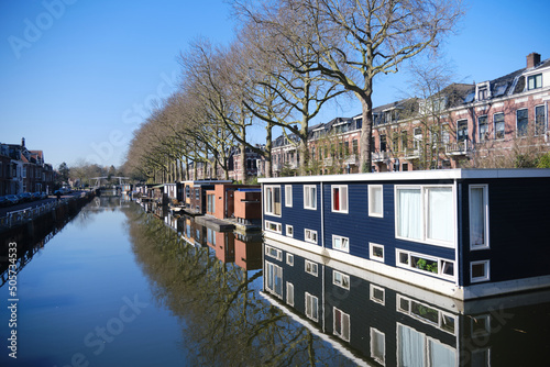 Canal quay covered in bright sunshine and floating home boats on the Leidse rijn canal in Lombok neighbourhood in Utrecht photo