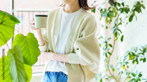 観葉植物に囲まれてリラックスする女性
 photo