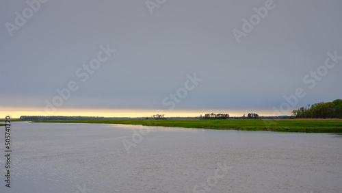 Fotografie Beautiful marshlands and a wide creek on a cloudy and drizzly evening near Cape