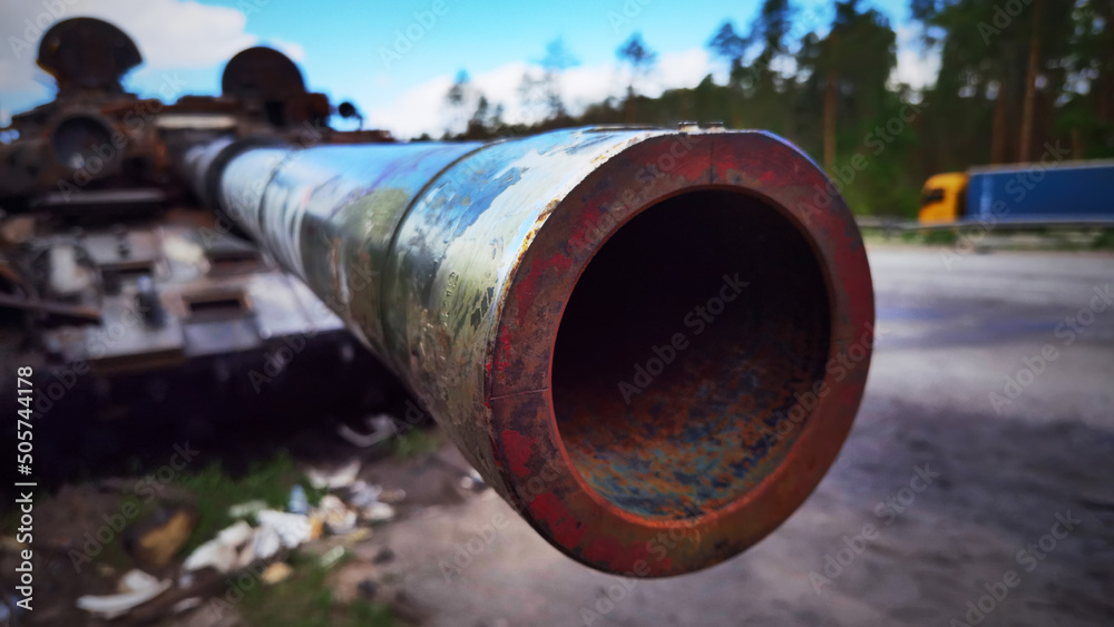 Kyiv region, Ukraine - May 15, 2022: War in Ukraine. Highway Kyiv - Zhytomyr. People take selfies against destroyed russian tank after russian atack in Febrary. Kyiv region, Ukraine - May 15, 2022: War in Ukraine. Highway Kyiv - Zhytomyr. People take selfies against destroyed russian tank after russian atack in Febrary.