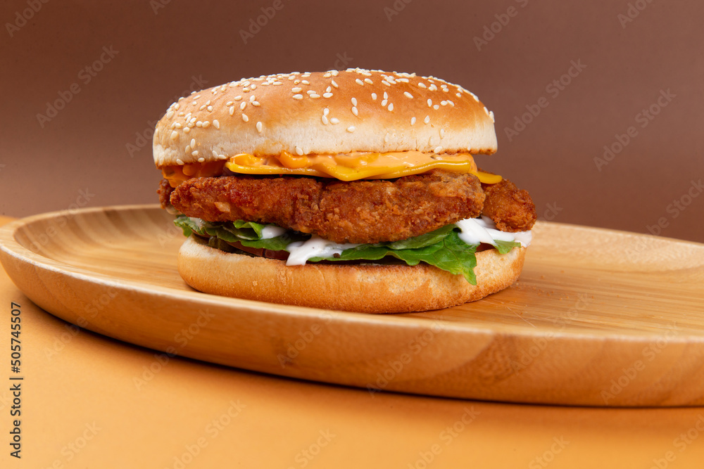 Classic chicken burger on a brown background. Classic chicken burger on a brown background.