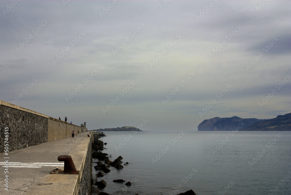 BEACH WITH CALM SEA AND ROCKS WITH CLOUDY SKY