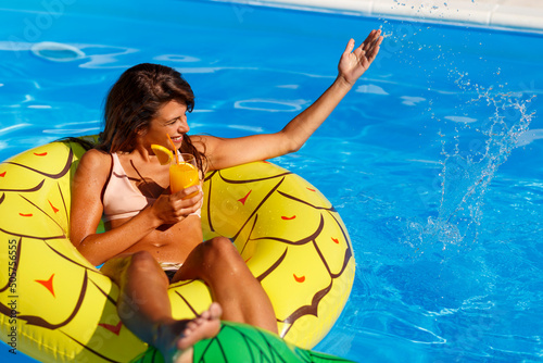Woman having fun at swimming pool while on summer vacation