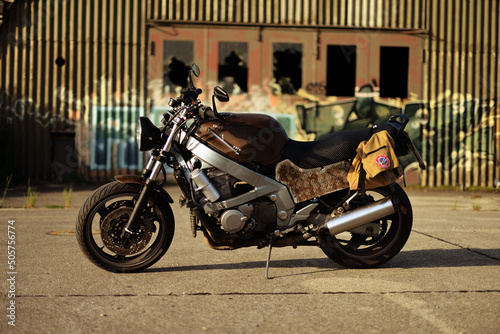 Altes rostiges Motorrad vor verlassener Lagerhalle