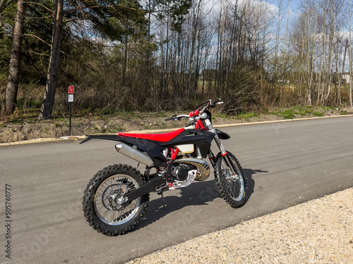 A red off-road motorcycle set on an asphalt road