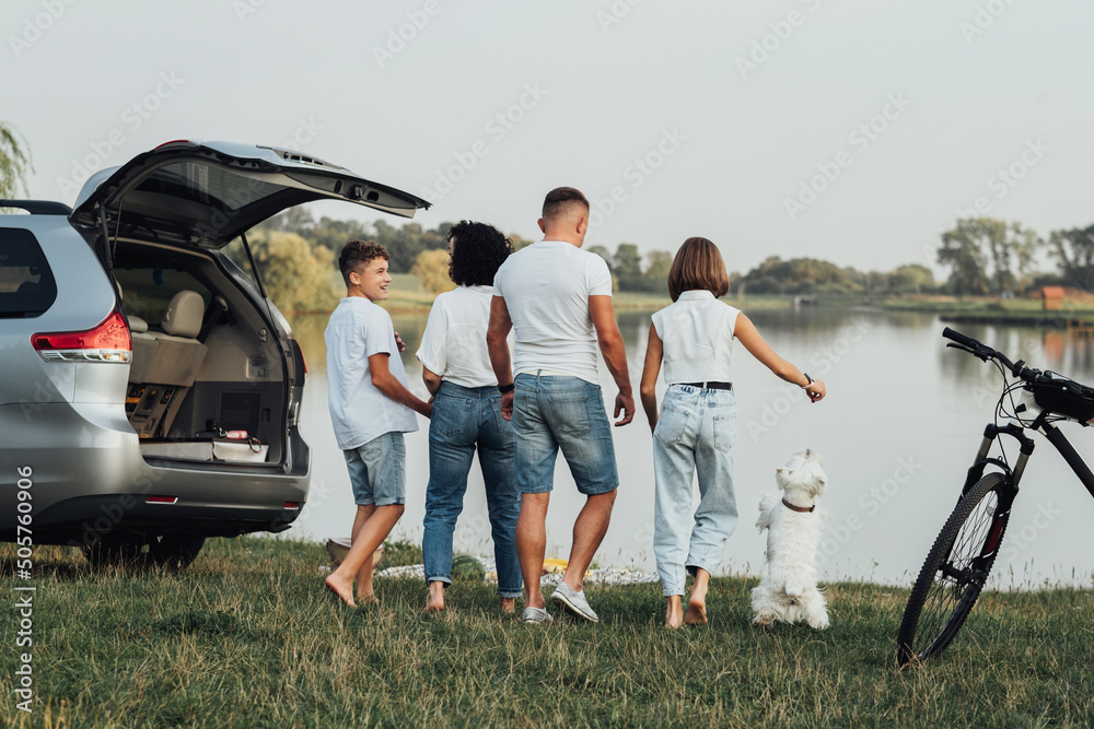 Φωτογραφία Four Members Family Traveling by Minivan Car and Having Picnic at Sunset by the
