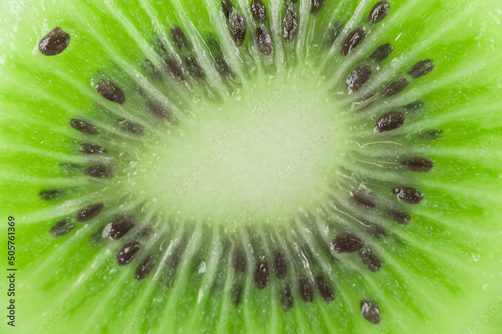 Background image: Juicy pulp of an exotic tropical fruit green kiwi with black seeds Background image: Juicy pulp of an exotic tropical fruit green kiwi with black seeds