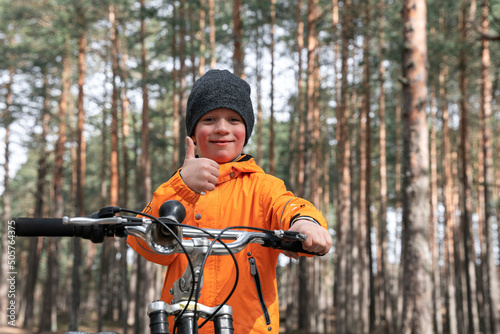 happy preschooler rides a bicycle through the park on a bike path 