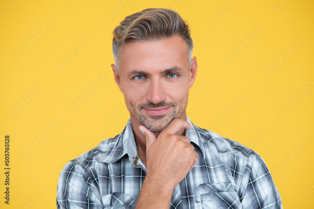 cheerful mature man with grizzle hair and smooth skin on yellow background