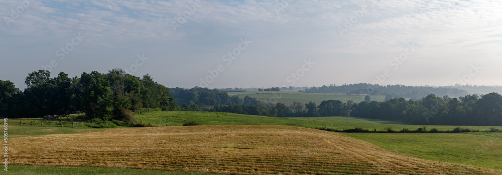 Amish farm fields and trees under a hazy sky in Holmes County, Ohio